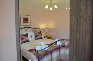 a bedroom with a bed and a mirror at Darly Cottage in Bourton on the Water