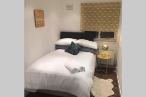 a bedroom with a white bed with towels on it at Large 3 bedroom apartment in gated development in London