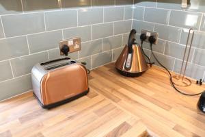 a toaster and a toaster sitting on a wooden floor at Large 3 bedroom apartment in gated development in London