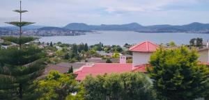 a view of a town with a lake and houses at Million Dollar Views in Hobart