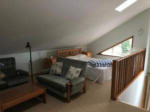 a bedroom with a bed and a couch and a chair at Araluen in Smiths Lake
