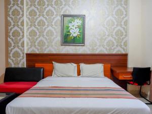 Ένα ή περισσότερα κρεβάτια σε δωμάτιο στο Pineapple Mansion Solo Mitra RedDoorz near RS JIH Solo