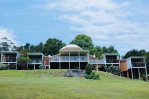 una casa grande en una colina con un campo verde en Casa Vista, en Bangalow