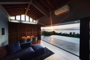 a living room with a couch and a view of the ocean at relax kouri villa Rekrrr in Nakijin
