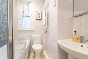biała łazienka z toaletą i umywalką w obiekcie Large 3 Bedroom modern apartment close to central London w mieście Finchley