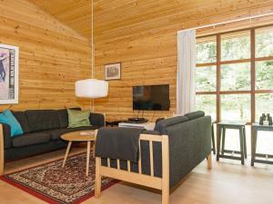 a living room with a couch and a tv at Peaceful Holiday Home in Jutland with Sauna in Ebeltoft