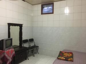a room with a mirror and a tv on a wall at Hotel SiCantik in Kaliurang