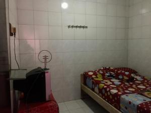 a small room with a bed and a small table at Hotel SiCantik in Kaliurang