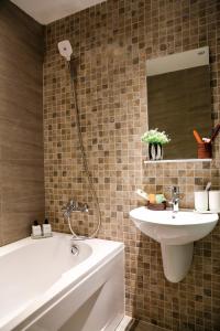 bagno con lavandino, vasca e specchio di Sen Spa Service Apartment ad Ho Chi Minh