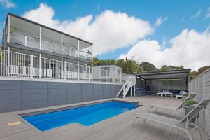 a house with a swimming pool and a deck at Peninsula Retreat in Rye