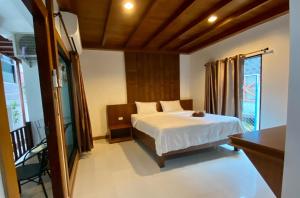 een slaapkamer met een bed en een groot raam bij Lipe Inn in Ko Lipe