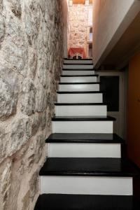 a stairway with black and white stairs and a stone wall at Private Accomodation Linda in Dubrovnik