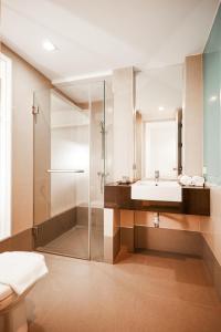 a bathroom with a glass shower and a sink at Studio Asoke in Bangkok