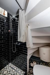 y baño con ducha, aseo y azulejos negros. en Private Accomodation Linda, en Dubrovnik