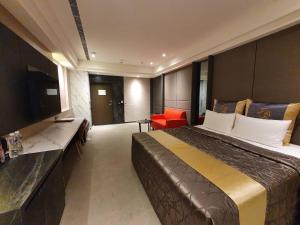 una camera d'albergo con un grande letto e una TV di Sun Motel a Kaohsiung