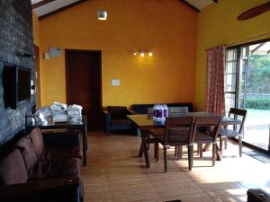a living room with a table and a couch at Jayshin Lake Vaitarna Resort - Igatpuri in Igatpuri