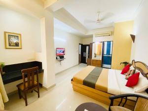 a hotel room with a bed and a desk at Hotel The Galaxy in Jabalpur