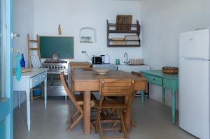 a kitchen with a wooden table and a refrigerator at Casa Falco Della Regina in Filicudi +36 photos