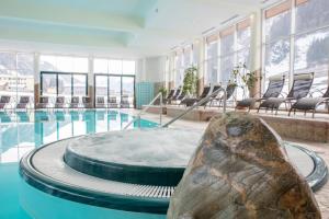 a large swimming pool with a large rock next to it at Rauriserhof 4 Sterne Superior in Rauris