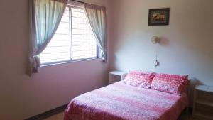 a bedroom with a pink bed with a window at Stokkiesdraai Holiday Apartments in St Lucia