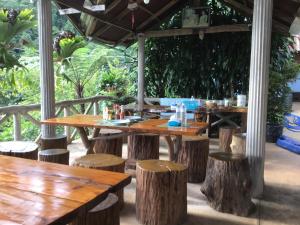 een houten tafel en stoelen onder een paviljoen bij Phu Plai Fah in Chiang Rai