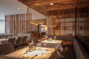 a dining room with tables and chairs and chandeliers at Rauriserhof 4 Sterne Superior in Rauris +53 photos
