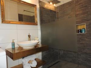 ein Bad mit einem Waschbecken und einem Spiegel in der Unterkunft Warmbad Apartments in Villach