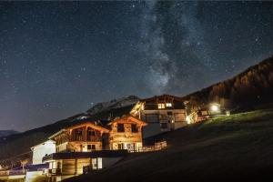 une maison sur une colline la nuit avec la voie laitière dans l'établissement Chalets - The Peak, à Sölden