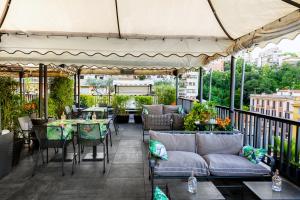 un patio con tavoli, divani, tavoli e sedie di Trilussa Palace Hotel Congress & Spa a Roma