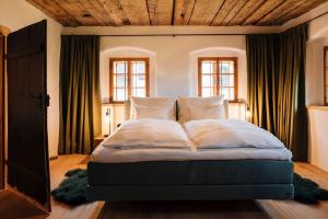 um quarto com uma cama grande e um tecto em madeira em BAUERNHAUS DÖRFL IN DER STRASS em Reindlmühl