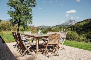 a wooden table and chairs with a view of mountains at BAUERNHAUS DÖRFL IN DER STRASS in Reindlmühl