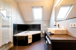 a bathroom with a sink and two windows at Villa Tilia in Retie