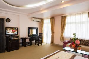 a living room with a couch and a television at Vien Dong Hotel 2 in Ho Chi Minh City