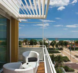 balkon ze stołem i krzesłami oraz widokiem na plażę w obiekcie Hotel Roma w mieście Riccione