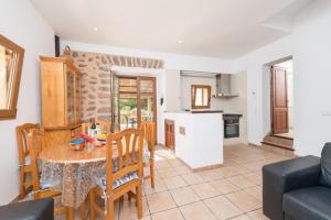 a kitchen and living room with a table and chairs at Can Tamany in Port de Soller