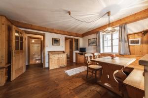 a living room with a wooden table and a kitchen at Hotel Fines in Funes