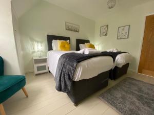 um quarto com uma cama grande e almofadas amarelas em Meadow House em Stamford