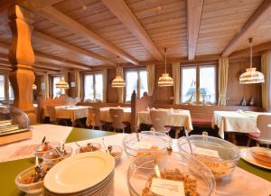 a restaurant with white tables and chairs and windows at Gästehaus Roseneck in Todtmoos