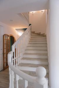 a staircase in a house with white stair railing at Mami Sabaudia Hotel in Sabaudia