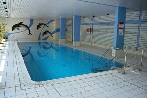 a large swimming pool with blue tiles and dolphins painted on the wall at Predigtstuhlblick Apartment - Terrasse - Pool - Panorama in Bad Reichenhall