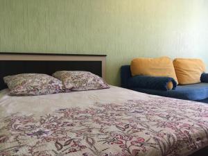 クルスクにあるApartament on Prospect Pobedy 44のベッドルーム1室(ベッド1台、青い椅子付)