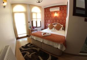 a bedroom with a bed and two windows at Boomerang Guest House in Selçuk