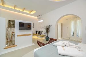 布拉卡Valena Mare Suites & Apartments的一间带床的白色卧室和一间客厅