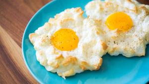 two fried eggs on a blue plate on a table at ODA Guest House in Korçë
