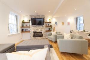 a living room with a fireplace and a tv at Queensferry Street Lane - Fantastic 2 BR City Centre Mews House with free secure parking! in Edinburgh