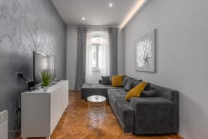 ein Wohnzimmer mit einem grauen Sofa und gelben Kissen in der Unterkunft Apartment LUX HOME in Rijeka