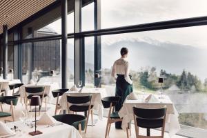a woman standing in a restaurant looking out the window at Farmhouse Milla Montis in Maranza +12 photos