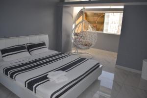 a bed with black and white sheets in a room at Blue Breeze in Luanda