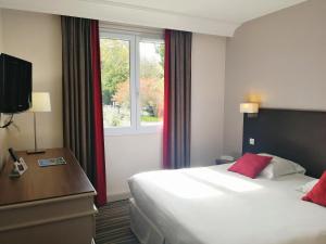 a hotel room with a bed and a window at Logis Hôtels- Hôtel et Restaurant Domaine de Fompeyre in Bazas