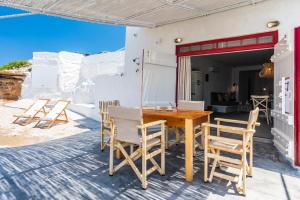 a wooden table and chairs on a patio at Achinos By The Sea Milos in Agia Irini Milos